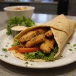 Delicious chicken shawarma wrap on a plate, displaying mouthwatering ingredients, representing chicken shawarma calories in a vibrant and appetizing way.